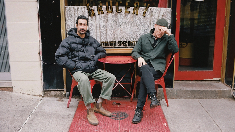 Photo of Frank & Tony sitting at a table outside a red cafe