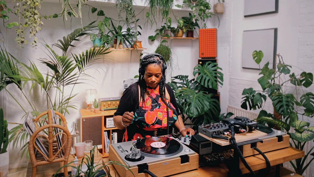 Photo of Marcia Carr DJing amongst a variety of plants