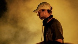 Photo of FDH DJing under a yellow light