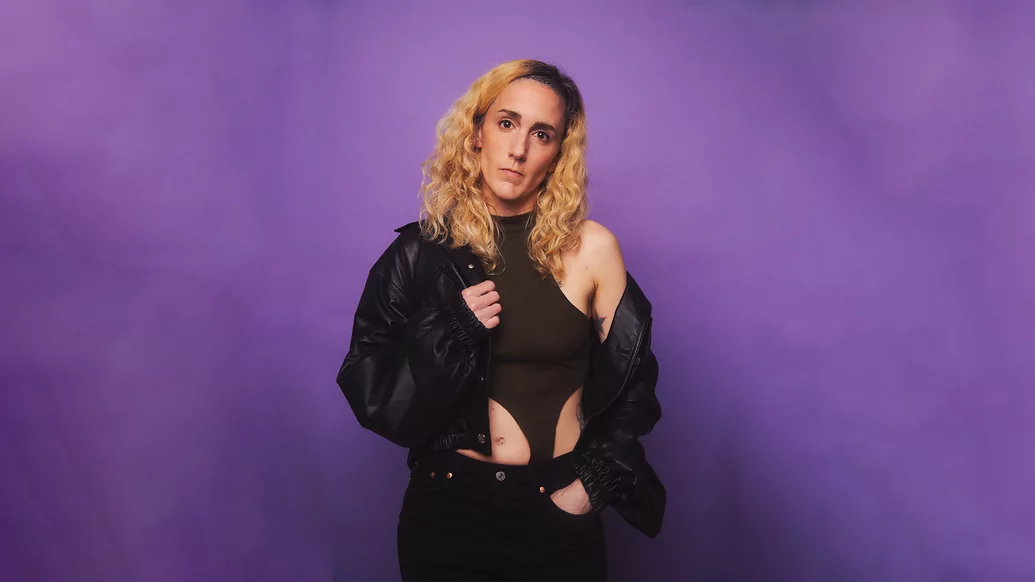 Lauren Flax standing against a purple background