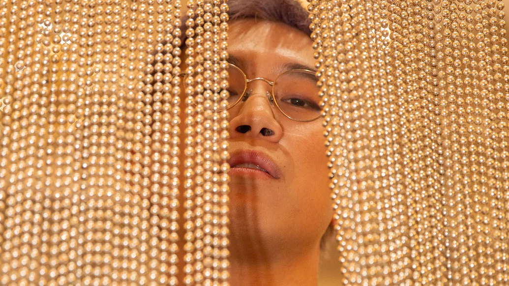Press shot of Mt Fuyu posing behind a curtain of white beads
