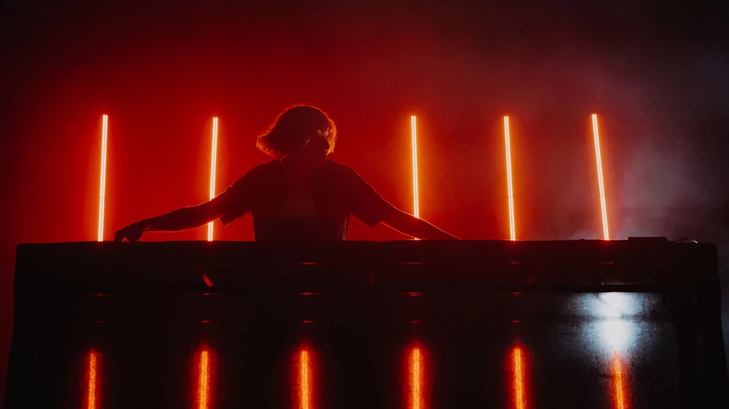 Daniel Avery playing live at Wide Awake festival in front of a row of red lights