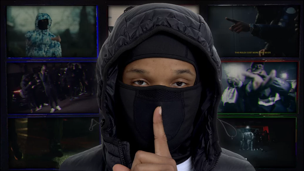 Photo of Chinx wearing a balaclava and pressing his finger to his lips in front of a TV screen graphic