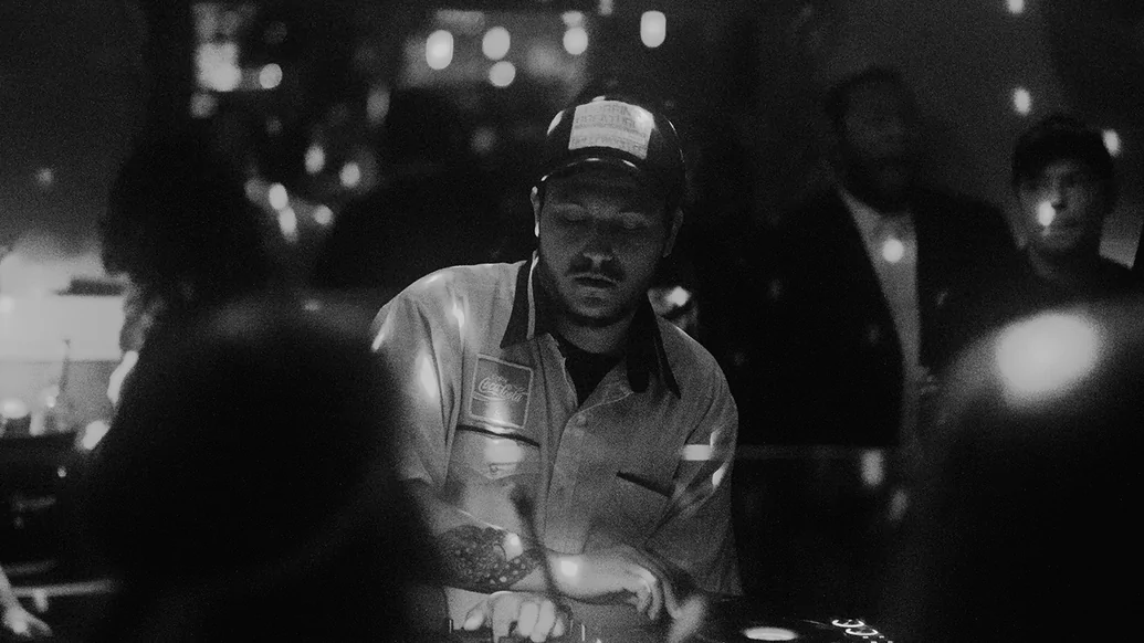 Black and white photo of Jonny From Space DJing in a club