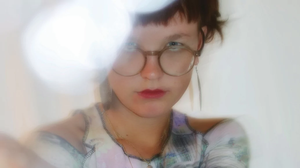 Photo of Chewlie wearing glasses and pink lipstick with a smudged lens