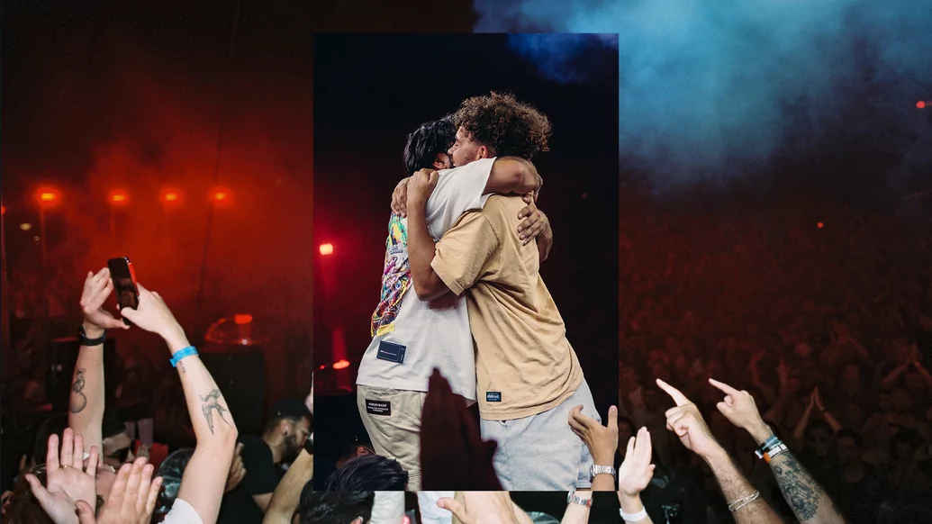 Photo of Jesse and Oz from ANOTR hugging against a background of a strobing club