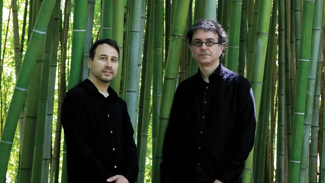 Photo of Donato Dozzy and Neel standing amongst a forest of bamboo