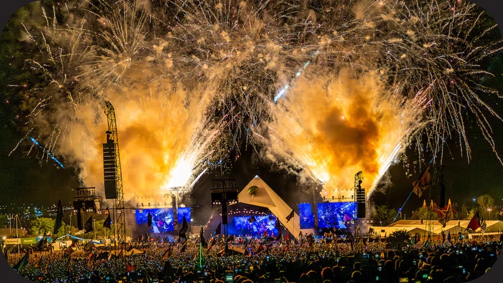 Photo of the Glastonbury Pyramid stage with huge, yellow fireworks going off