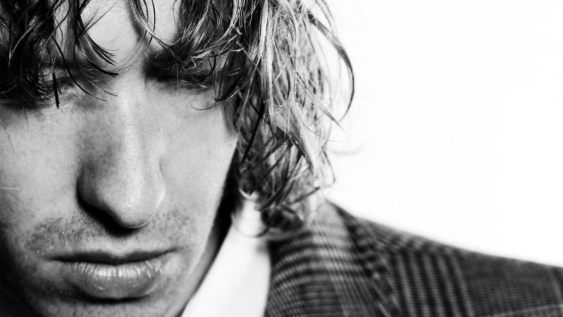 A close up black and white shot of daniel avery's face, which is looking down