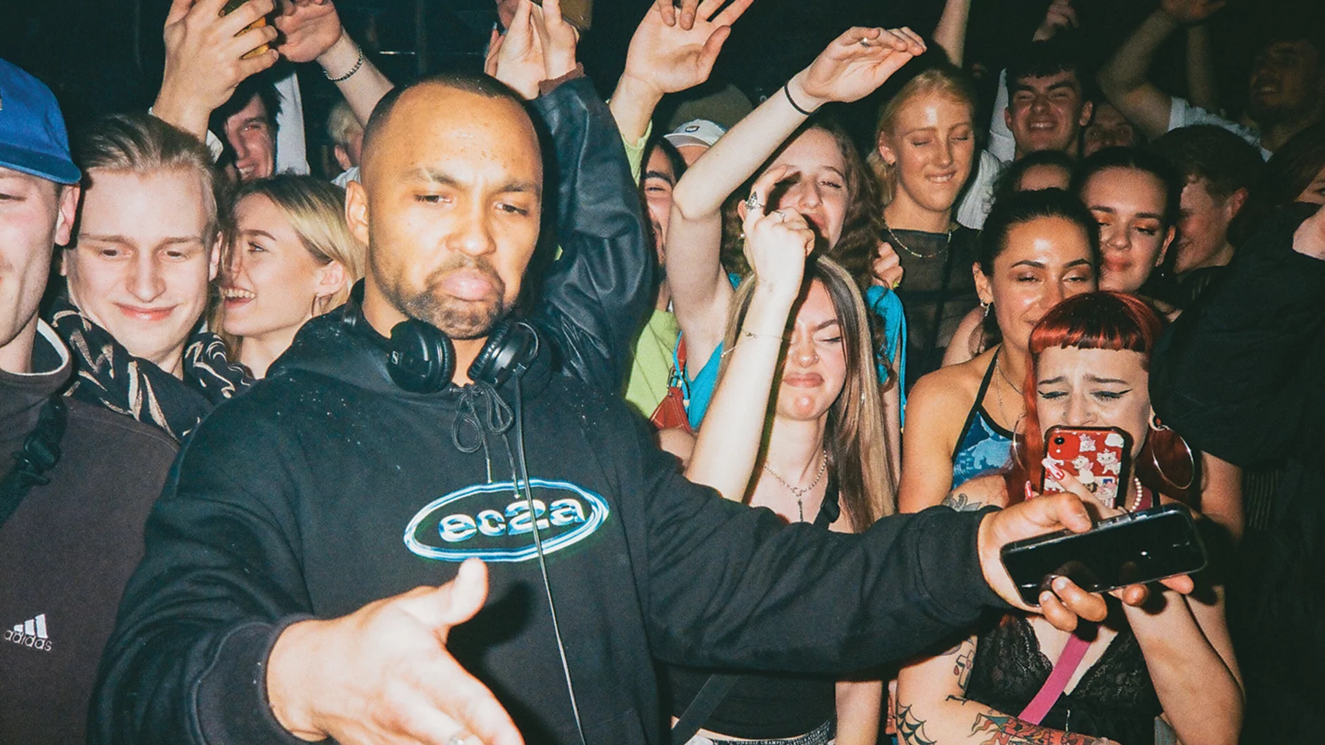Dr Dubplate DJing in an ec2a hoody surrounded by a crowd of ravers