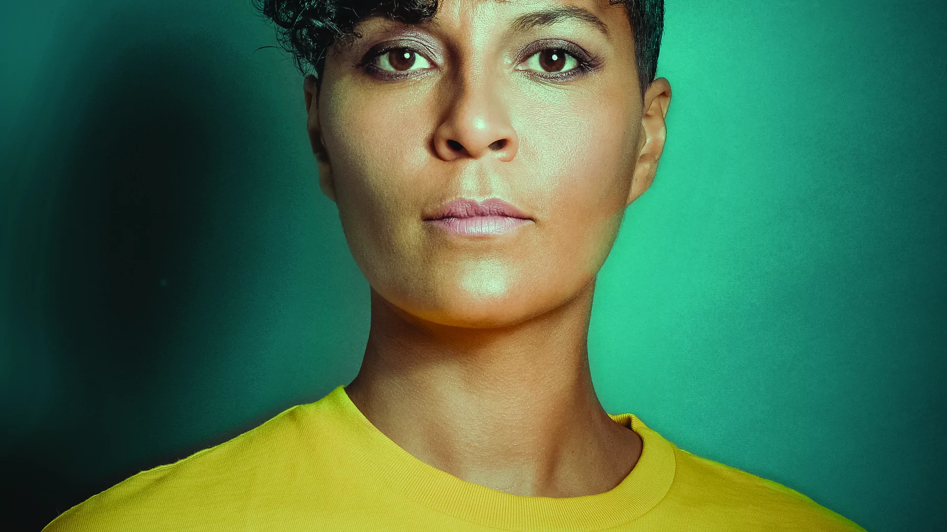 Virginia poses in a portrait image wearing a yellow top
