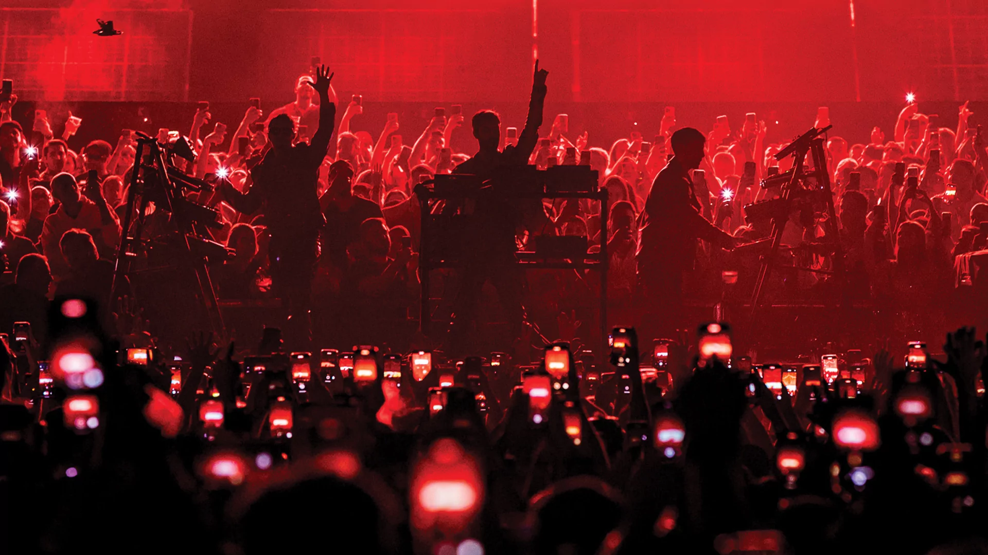 Photo of Meduza playing together in front of a big crowd under red lights