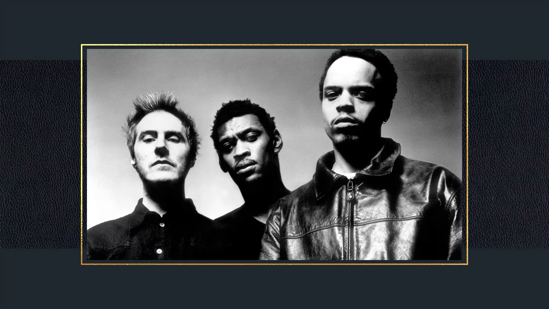 Black and white photo of Massive Attack in 1998 on a dark blue background