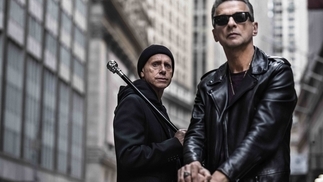 Dave Gahan and Martin Gore of Depeche Mode standing on a city street with canes in their hands.