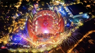 A drone photo of 2022’s UNTOLD Festival arena with flashing lights and fireworks