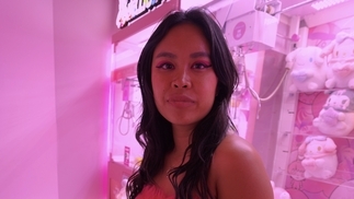 Photo of Maggie Tra in front of a pink arcade claw machine