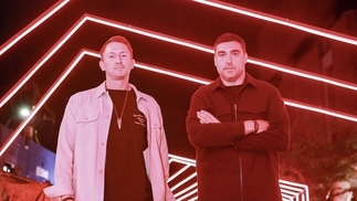Photo of CamelPhat posing in front of red ceilings lights in Medellín, Colombia