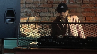 Photo of Gacha Bakradze DJing in front of a brick wall