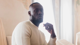Photo of Stormzy wearing a cream jumper against a cream background