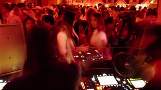 A crowd moves in a blur in front of the Dj decks at the new Miami venue, Jolene Sound Room