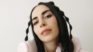Photo of Matisa with braided hair and wearing a baby pink jacket