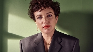 Photo of DJ Annie Mac wearing a grey suit and red lipstick