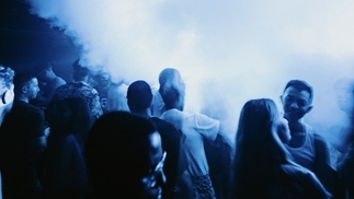 Photo of clubbers inside fabric with blue lights and smoke