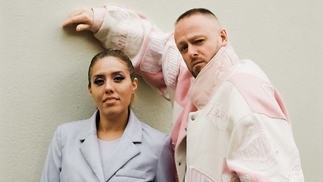 Photo of Bianca Oblivion and Sam Binga in pastel outfits leaning against a wall