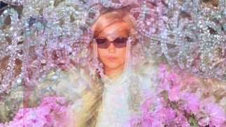 Photo of Sha Sha Kimbo wearing black sunglasses surrounded by glitchy pink flowers and lights
