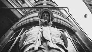 Black and white photo of DJ and producer R U OFF wearing a hooded coat 