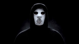 Photo of Angerfist wearing a white mask and black cloak