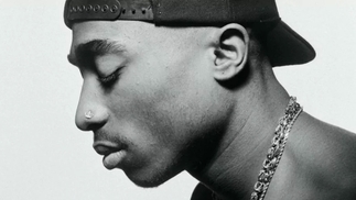 Tupac Shakur poses in a baseball cap in a black-and-white image