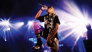Photo of OneDa performing on stage wearing a scarf and leopard print trainers
