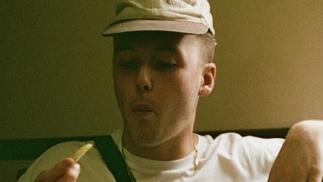 Photo of Elpac wearing a beige hat and eating a chip