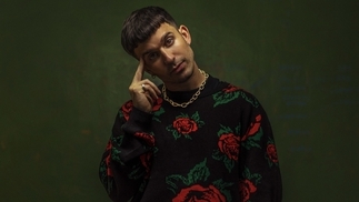 Photo of Michael Bibi wearing a black jumper with roses 