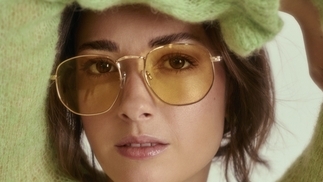 Photo of Sinca wearing a green fluffy jumper and yellow-tinted sunglasses