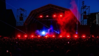 Photo of a stage in red lights at Riverside festival at night