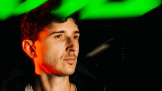 Photo of RL Grime wearing a black puffer with green and red lights
