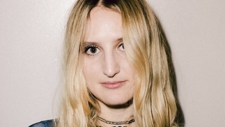 Photo of Carré wearing a silver choker and blue top