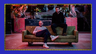 Photo of Eamon Harkin and Justin Carter DJing sitting on a green sofa in a pink-lit warehouse