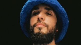 Photo of Folamour wearing a blue fluffy bucket hat