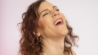 Photo of Eris Drew laughing against a pale pink background