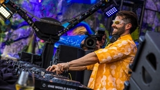 Alok DJing at Tomorrowland in an orange shirt and sunglasses