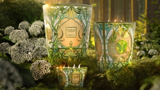 Three glowing Tomorrowland candles sit in green and yellow jars in a forest