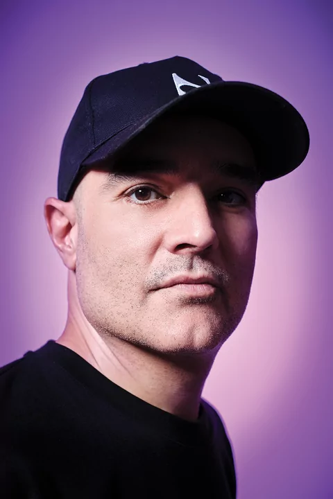 Paco Osuna profile shot wearing a black baseball cap