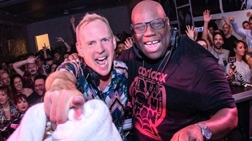 Fatboy Slim and Carl cox with their arms around eachother at a club