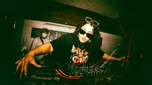 Photo of Manara DJing in shades