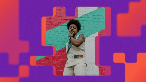 Press shot of Chmba leaning against a wall. The photo is on an abstract purple and orange background in the same style as the 'Synergy' album artwork