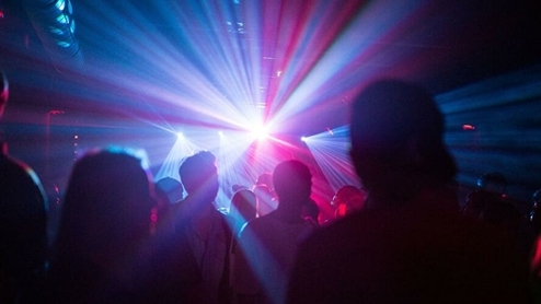 Photo of dancers and colourful lights inside a nightclub
