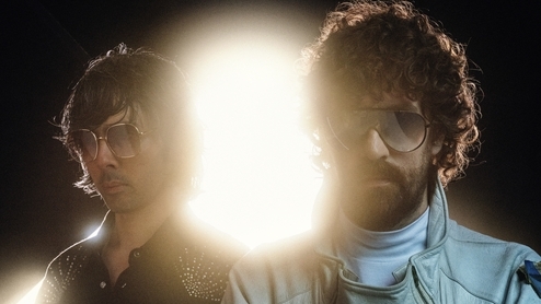 Photo of Gaspard Augé and Xavier de Rosnay (Justice) wearing sunglasses in front of a bright light